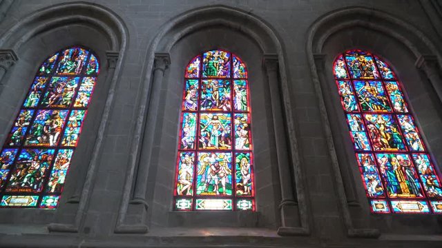 Beautiful roman stained glasses in a Church - cinematic dolly shot. Medieval art - Bible iconography