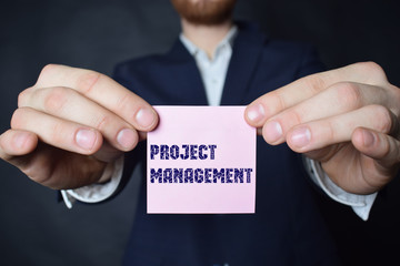 A businessman shows an inscription:PROJECT MANAGEMENT