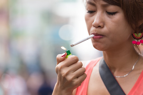 close up of Asian middle age woman smoking a cigarette