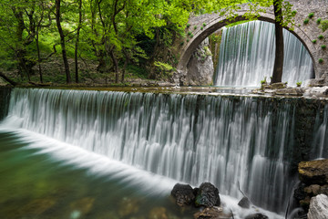Traditional stone bridge and waterfalls near Paleokaria village in Thessaly, Greece
