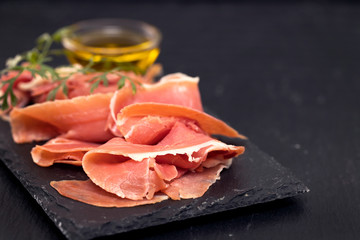 prosciutto on black ceramic board