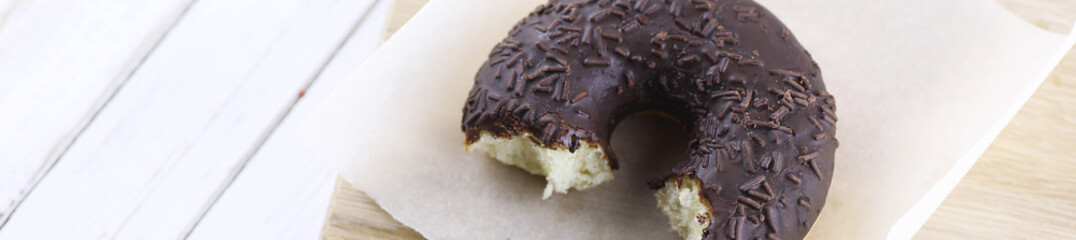 Horizontal bakground of chocolate donuts on a table