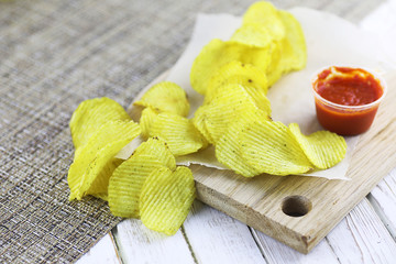 Potato chips on a wooden tray