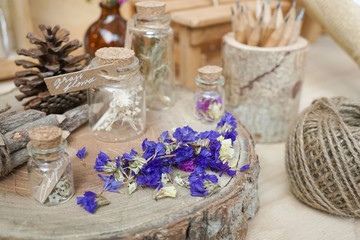 Obraz na płótnie Canvas dried flowers on the wooden stump display with selective focus on the dried statice flowers (purple flowers). vintage and nostalgic still life.