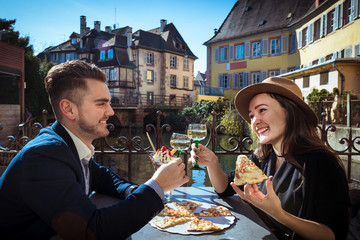 Young woman with boyfriend has lunch in Alsace. Two people sits together in local cafe with pizza...