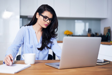 Young woman working on laptop in home office