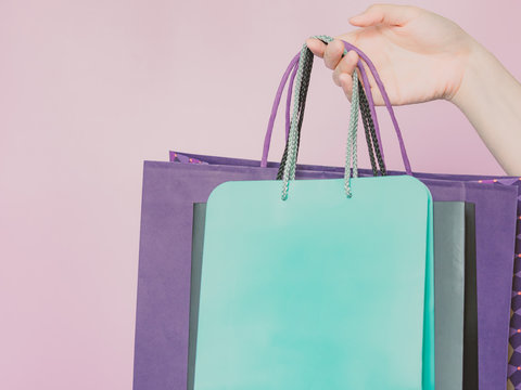 business ,finance and shopping concept from beauty woman hand hold group of pastel paper shopping bag by right hand with pink pastel isolated background
