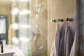 Luxury towels on oor hooks in modern bathroomin front of mirror.