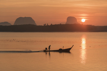 Silhouette scene of a fisherman sailing in the sea in the morning