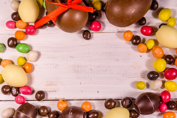 Chocolate easter eggs on a white wooden table. Top view