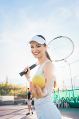 Woman going about playing Tennis showing the ball