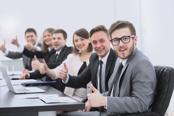 business team with thumbs up while sitting at his Desk