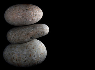 Fototapeta na wymiar Balancing rocks against a black background.