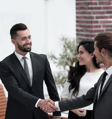 handshake business partners in the office.