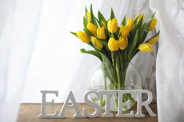 A bouquet of yellow tulips in a vase on the windowsill. A gift t