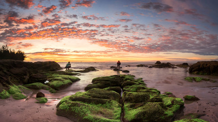 Stitched Panorama of sunset at the beach with natural coastal rocks. nature composition.
