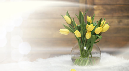  bouquet of yellow tulips in a vase on the floor