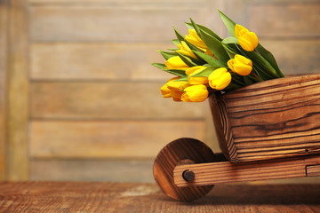 A bouquet of yellow tulips in a vase on the floor. A gift to a w