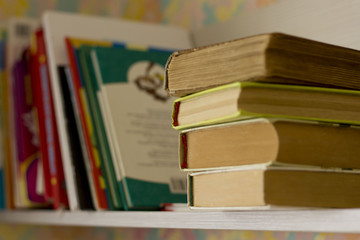 thick books on a wooden shelf