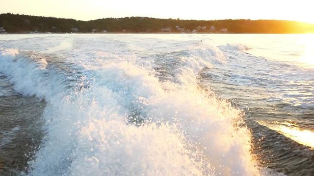 Slow motion a wake of a large boat at sunset on the water