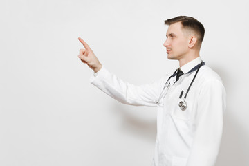 Serious young doctor man isolated on white background. Male doctor in medical gown, stethoscope touch something like click on button, push on copy space. Healthcare personnel, health, medicine concept