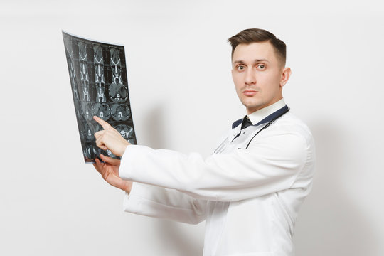 Serious handsome young doctor man holds x-ray radiographic image ct scan mri isolated on white background. Male doctor in medical uniform, stethoscope. Healthcare personnel, health, medicine concept.