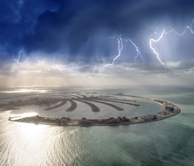 Amazing aerial view of Palm Jumeirah Island in Dubai from helicopter against sunset sky