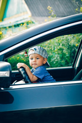 Little boy driving a car looking out the window