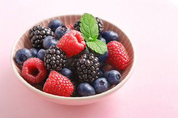 Berry (raspberry, blueberry, blackberry) fruits bowl on a pastel background. 