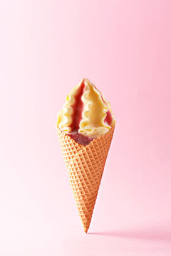 Ice cream cone on a pastel background. Refreshing strawberry vanilla ice cream with a wafel cone isolated on pink pastel background. Summer concept