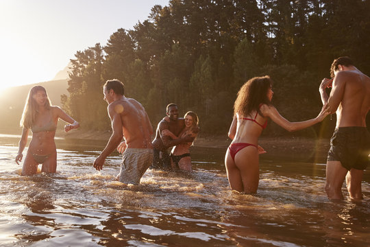 Young adult friends on vacation playing in a lake