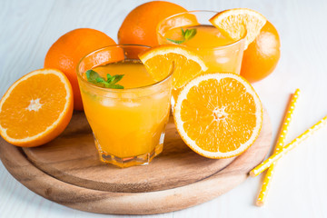 Close-up of a glass of orange juice with oranges fruits on wooden and stone background. Vitamins and minerals. Healthy drink and beverage concept.