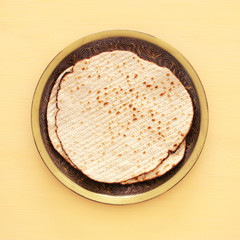 passover background with matzoh over yellow wooden background.