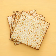 passover background with matzoh over yellow wooden background.