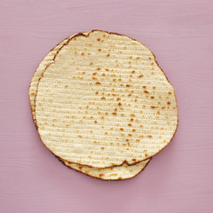 passover background with matzoh over light purple wooden background.
