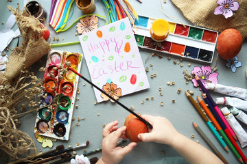 A child paints Easter eggs. Easter composition
