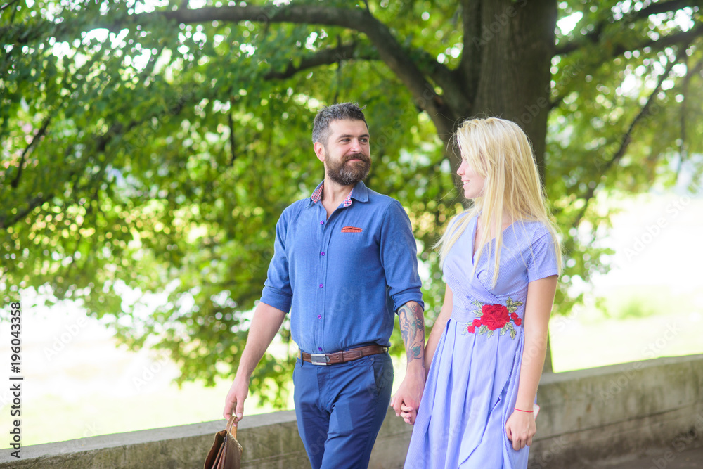 Wall mural Romantic couple concept. Bearded man walks with his girlfriend.