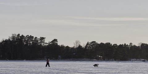 Fototapeta na wymiar People walking on the frozen sea, Espoo, Finland
