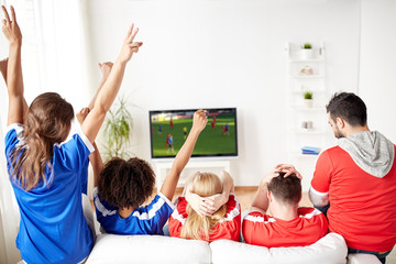 friends or soccer fans watching game on tv at home