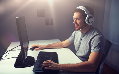 man in headset playing computer video game at home