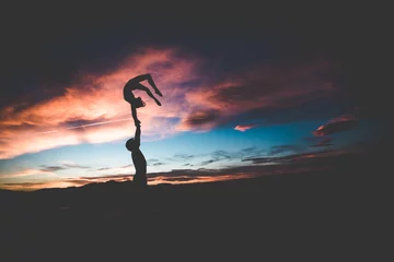 Zelfklevend Fotobehang acrobatics silhouette in the sunset yoga © Luke