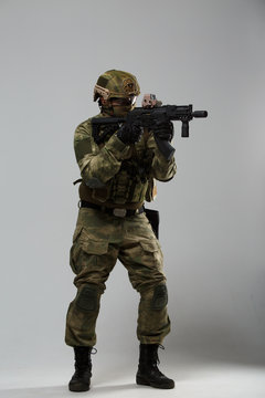 Full-length portrait of soldier in camouflage with gun