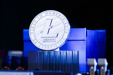 Image of crypto currency litecoin and processor on blue background