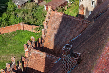 Fototapeta na wymiar Aerial view of red tile roof of the Church of St. Great Martyr George the Victorious in Pravdinsk (Friedland), Kaliningrad Oblast, Russia. The Church was erected 1360-1380, rebuilt in the 15th century