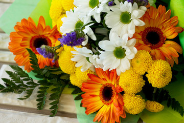 A wedding story or background Mother's Day. Bouquet of gerbera and chrysanthemums on a stone background.
