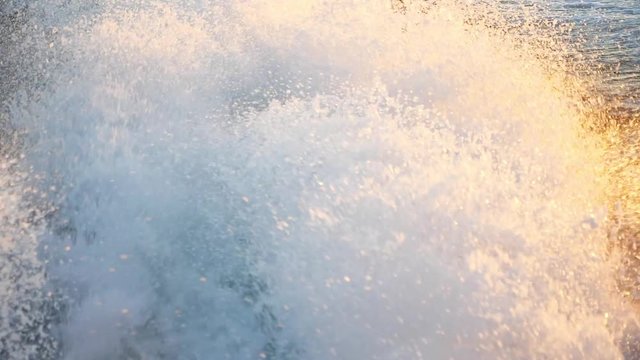 Slow motion of a wake of a large boat at sunset on the water