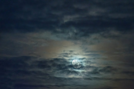 Fototapeta Księżyc na zachmurzonym niebie.