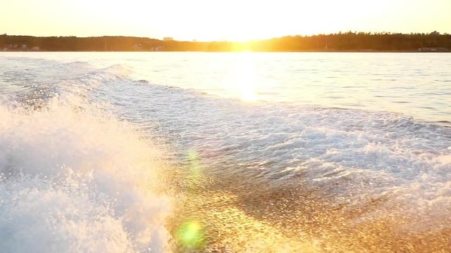 Slow motion of a wake of large boat at sunset on the water