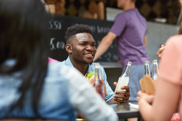 friends with drinks sitting at table at food truck