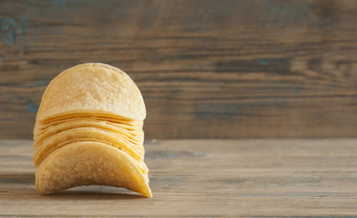 Golden natural potato chips on an old wooden table